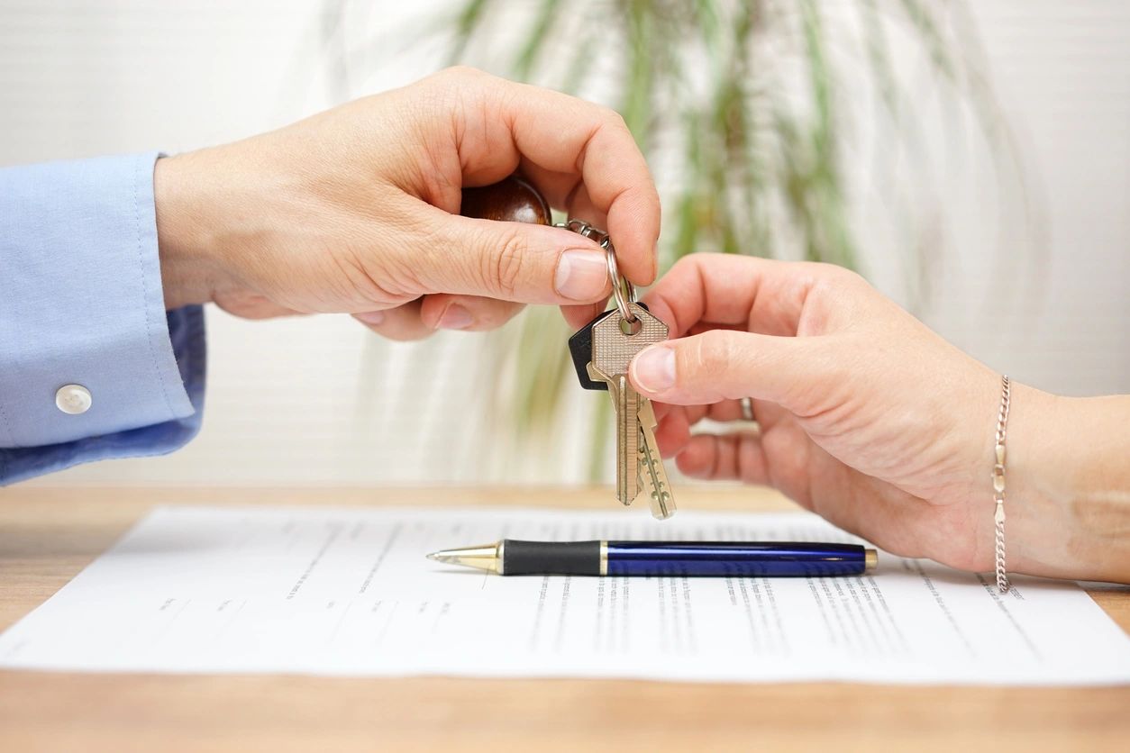 Person giving key to another person